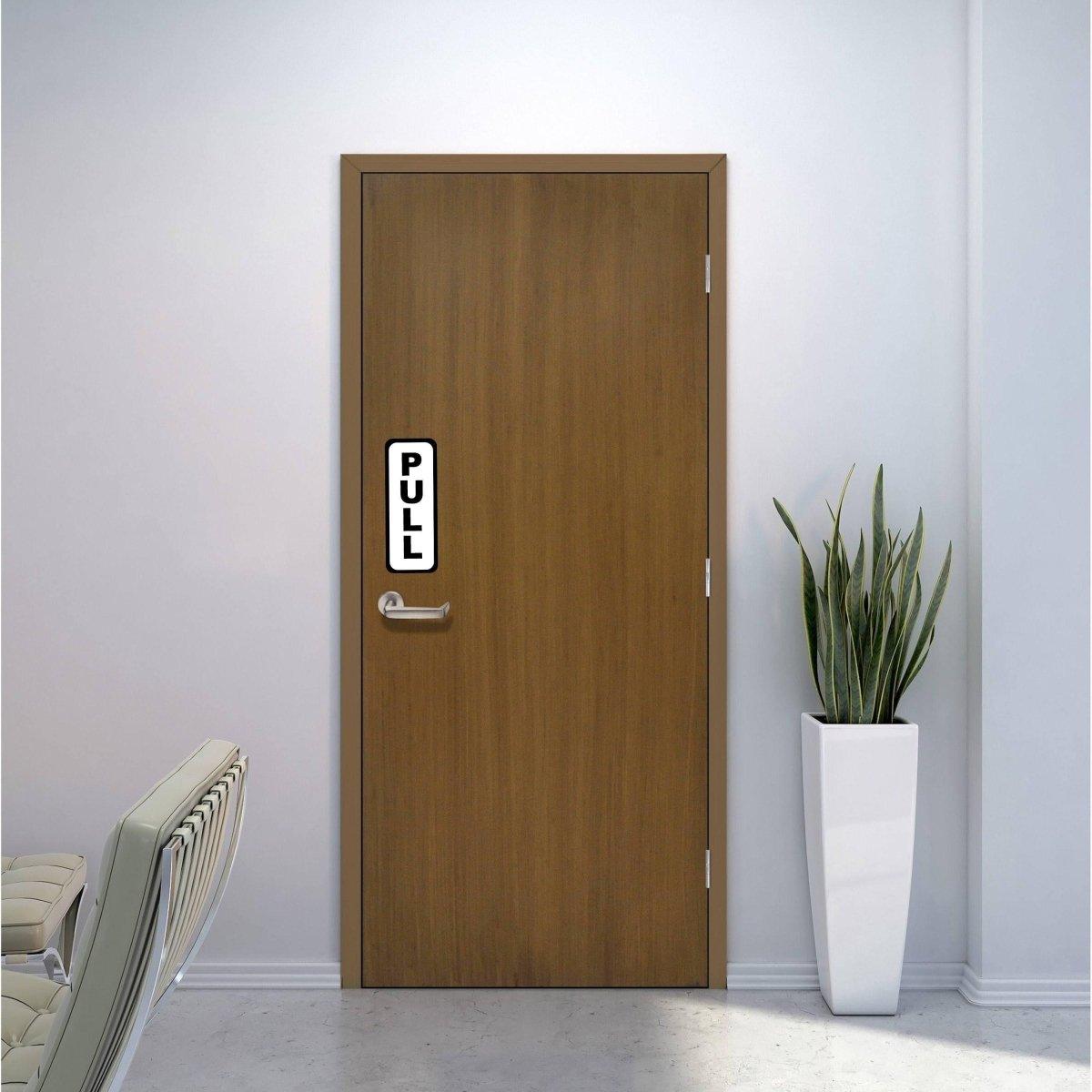 Adhesive doorway directional signage kit with a 'PULL' sign on a wooden door in an indoor setting.