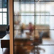 Frosted window film decal offering privacy while allowing natural light to illuminate a modern workspace.