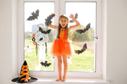 Bat-shaped silhouette vinyl decals displayed on a window in a decorated room.