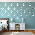 Vinyl vintage anchor wall decals in white on a blue wall, enhancing a nautical-themed bedroom decor.